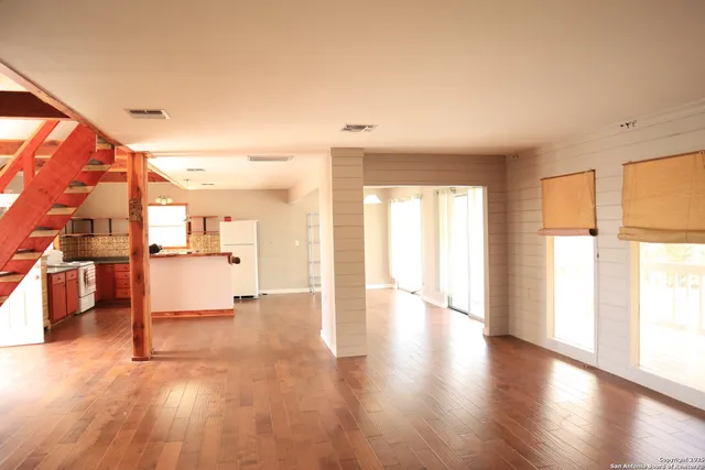 a view of a living room hardwood floor and a kitchen