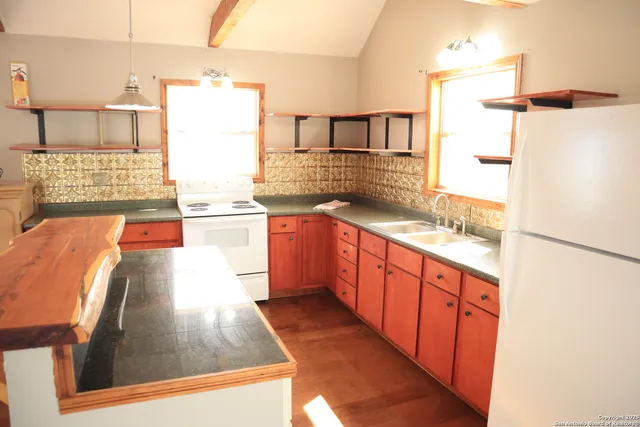 a kitchen with stainless steel appliances granite countertop a refrigerator a stove and white cabinets