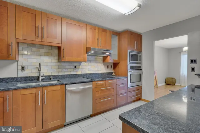 a kitchen with granite countertop wooden cabinets and a sink