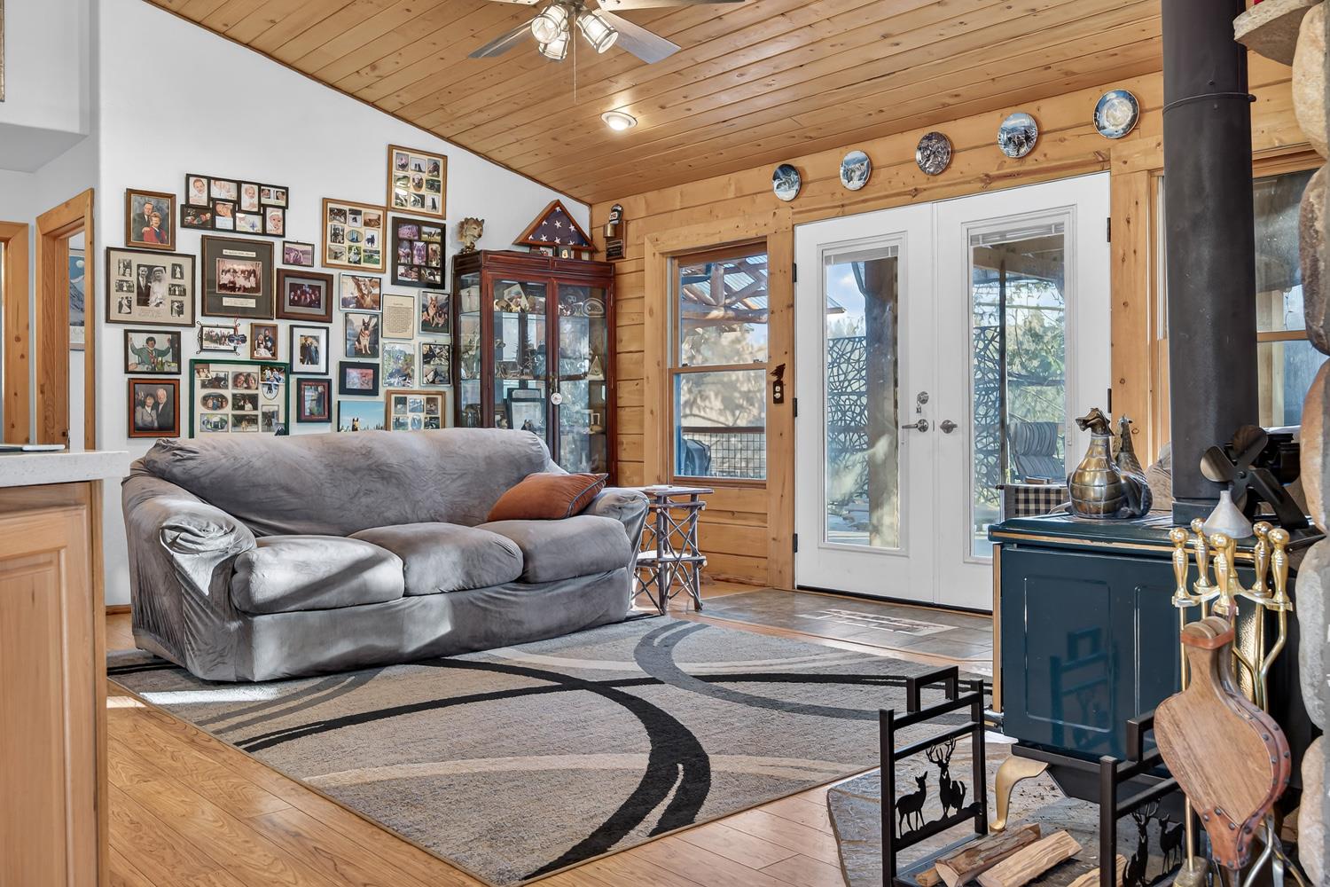 10394 Ponderosa Way Mountain Ranch, CA 95246 - Photo 14 of 58 a living room with furniture a flat screen tv and a floor to ceiling window