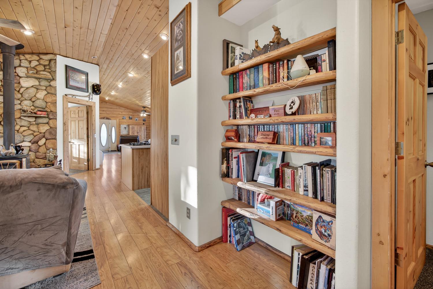 10394 Ponderosa Way Mountain Ranch, CA 95246 - Photo 26 of 58 a living room with furniture and a book shelf