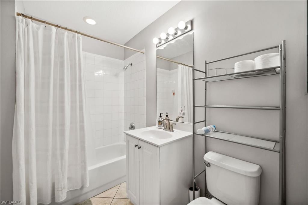 8355 Whisper Trace Lane, Unit K104 Naples, FL 34114 - Photo 11 of 21 a bathroom with a granite countertop sink toilet and shower