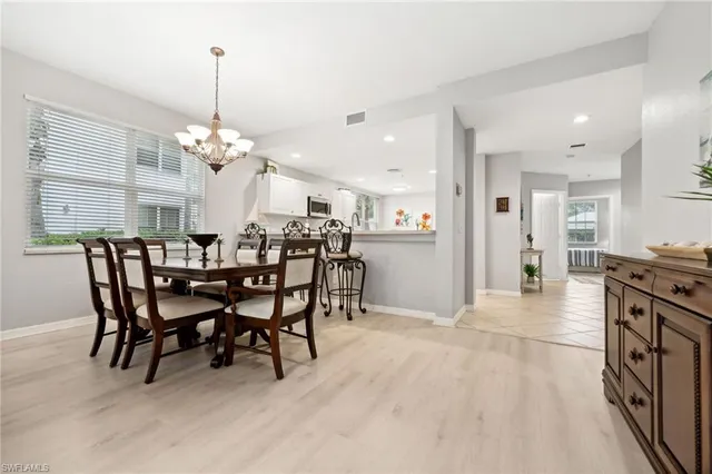 a view of a dining room and livingroom with furniture wooden floor a chandelier