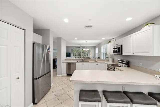 a kitchen with a sink a refrigerator and white cabinets