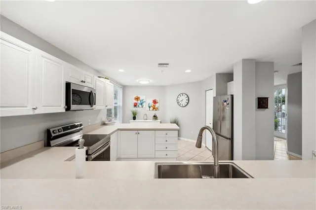 a kitchen with stainless steel appliances kitchen island granite countertop a refrigerator and a stove top oven