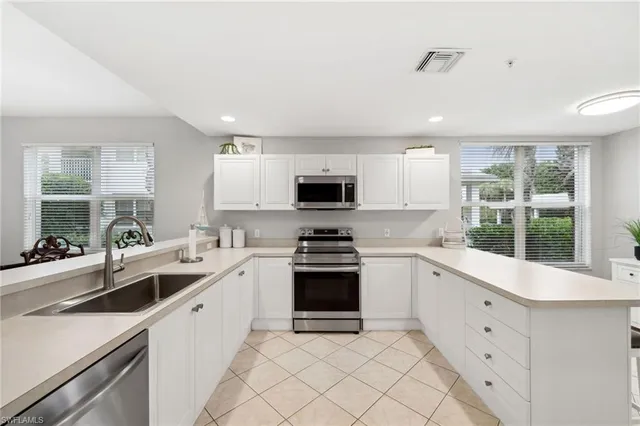 a kitchen with white cabinets and appliances