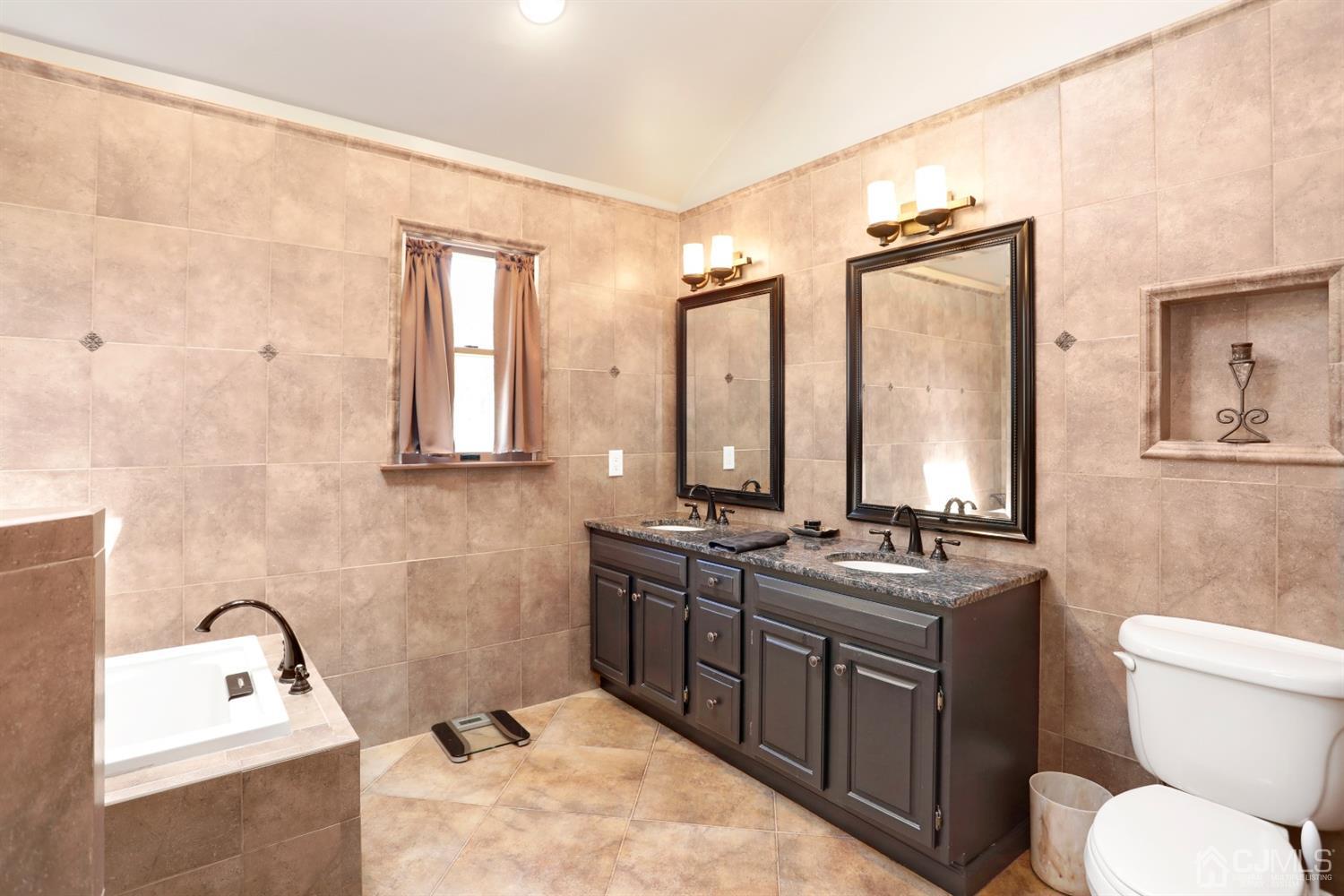 2 Astor Drive Manalapan, NJ 07726 - Photo 45 of 60 a bathroom with a tub sink toilet and mirror