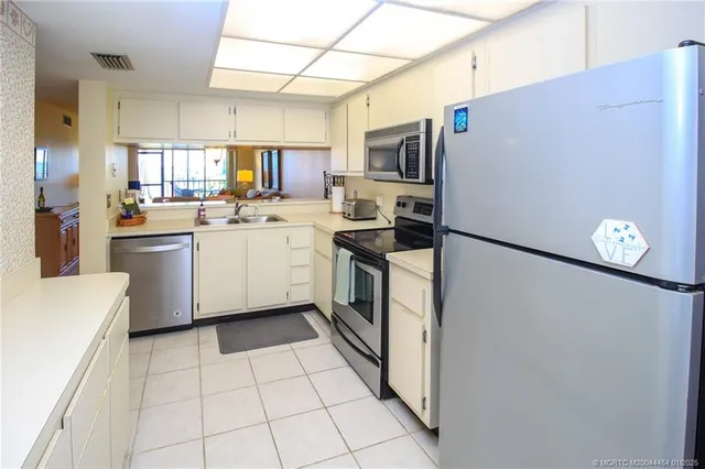 a kitchen with stainless steel appliances a refrigerator sink and cabinets