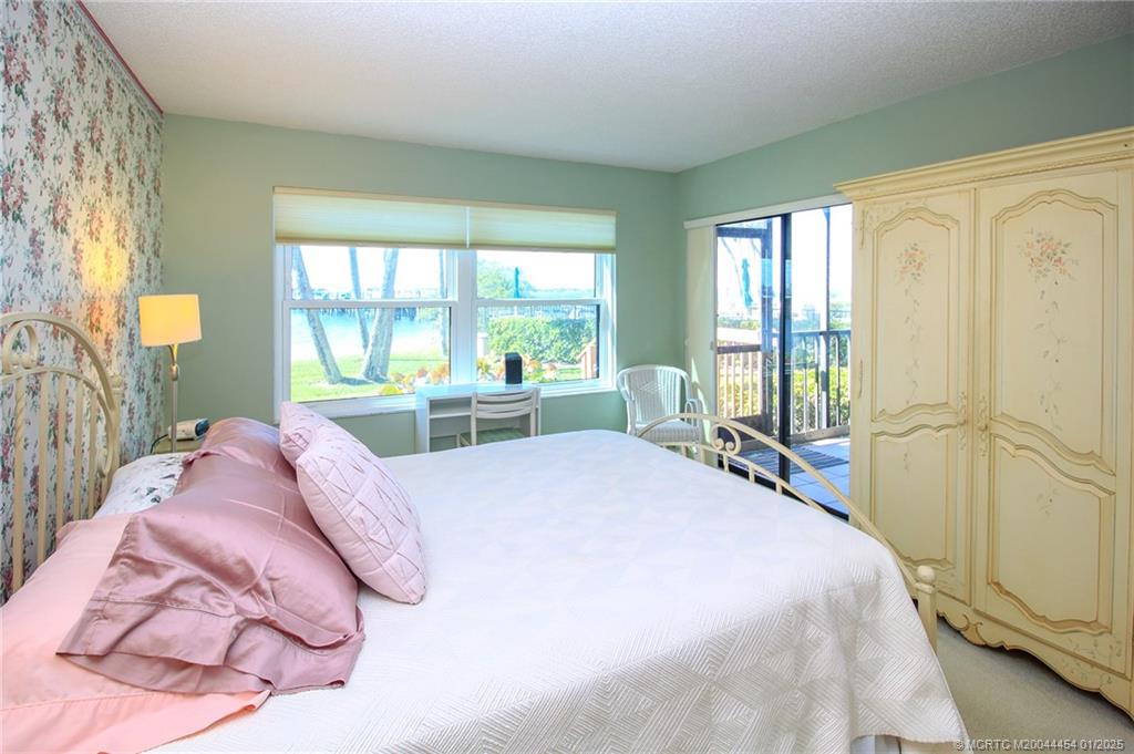 4540 Northeast Sandpebble Trace, Unit 105 Stuart, FL 34996 - Photo 13 of 39 a bed sitting in a bedroom next to a window
