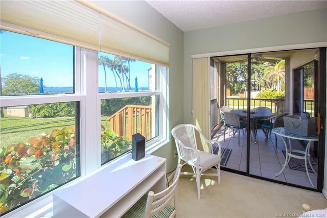 a view of a dining room with furniture large windows and wooden floor
