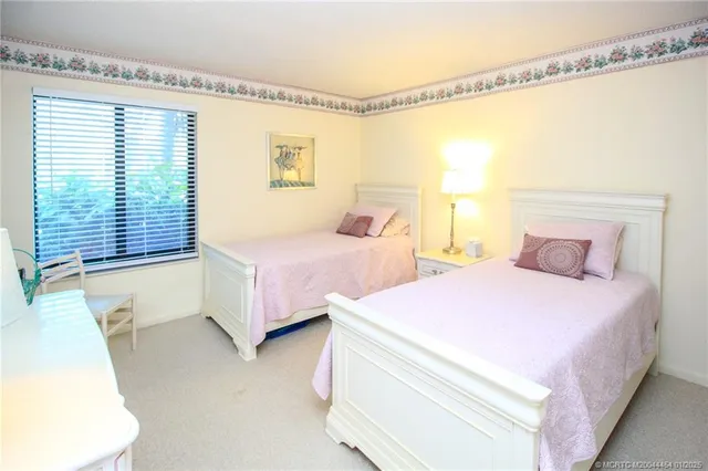 a bedroom with two beds and large window