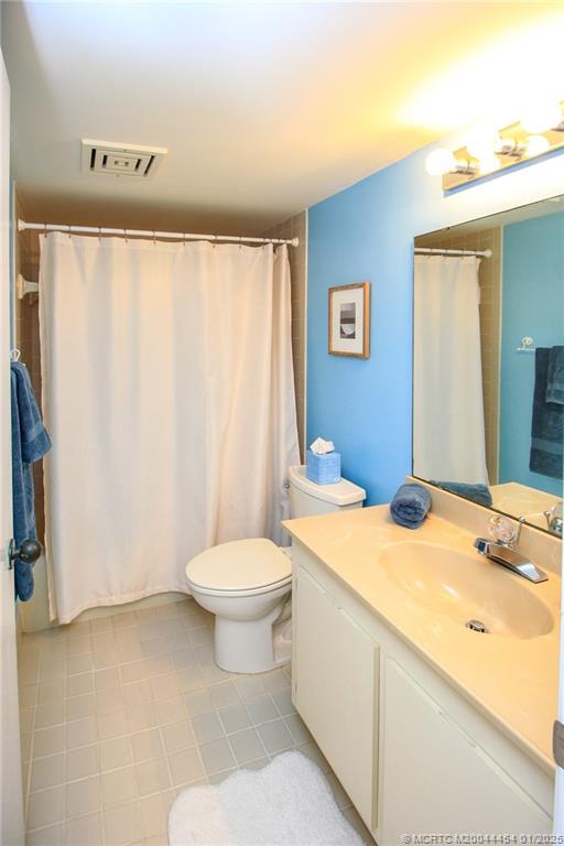 4540 Northeast Sandpebble Trace, Unit 105 Stuart, FL 34996 - Photo 21 of 39 a bathroom with a sink a toilet and a mirror