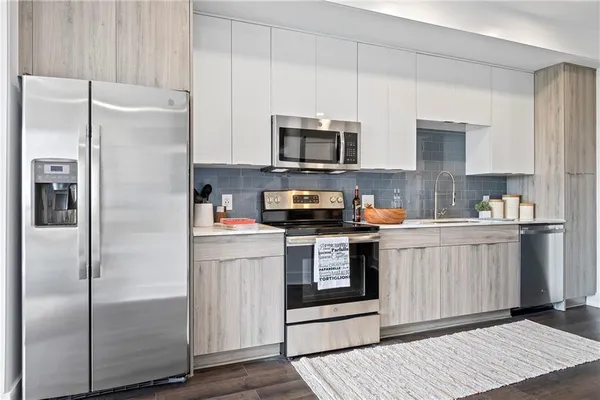 a kitchen with stainless steel appliances and white cabinets