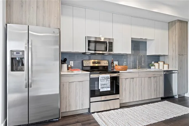 a kitchen with stainless steel appliances and white cabinets