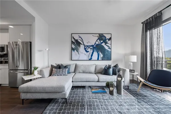 a living room with furniture a rug and a large window