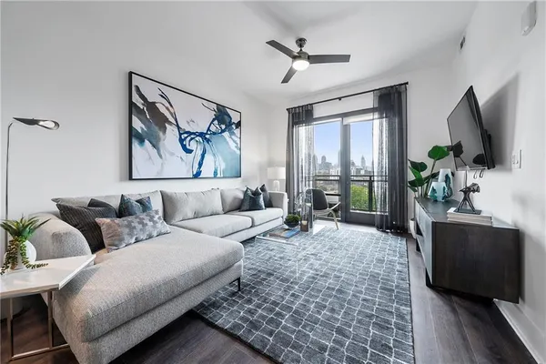 a living room with furniture a large window and a flat screen tv