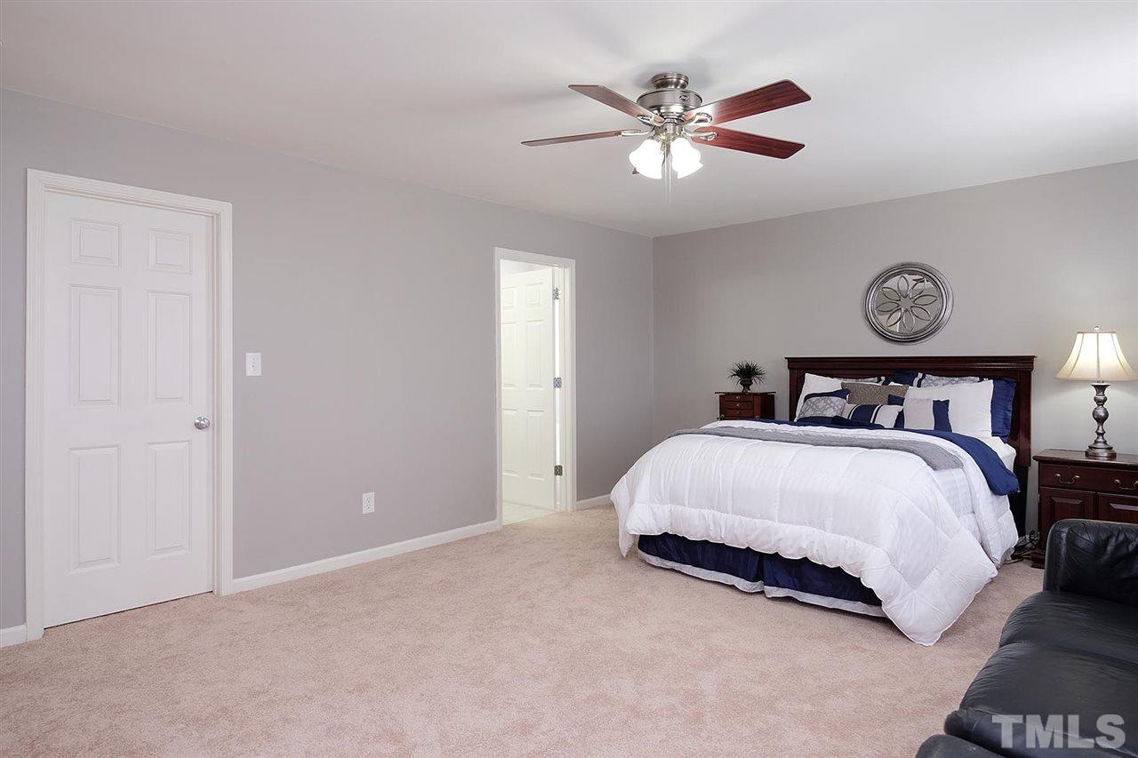 613 Hanson Road Durham, NC 27713 - Photo 17 of 25 a bedroom with a bed and a ceiling fan