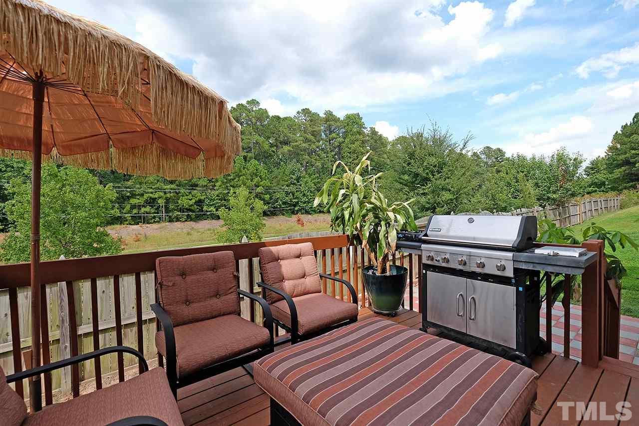 613 Hanson Road Durham, NC 27713 - Photo 23 of 25 a terrace of a house with barbeque oven and a garden