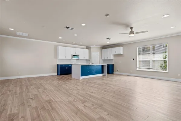 a view of empty room with wooden floor and window