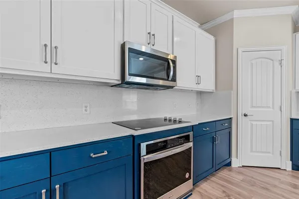 a kitchen with granite countertop a sink cabinets and wooden floor