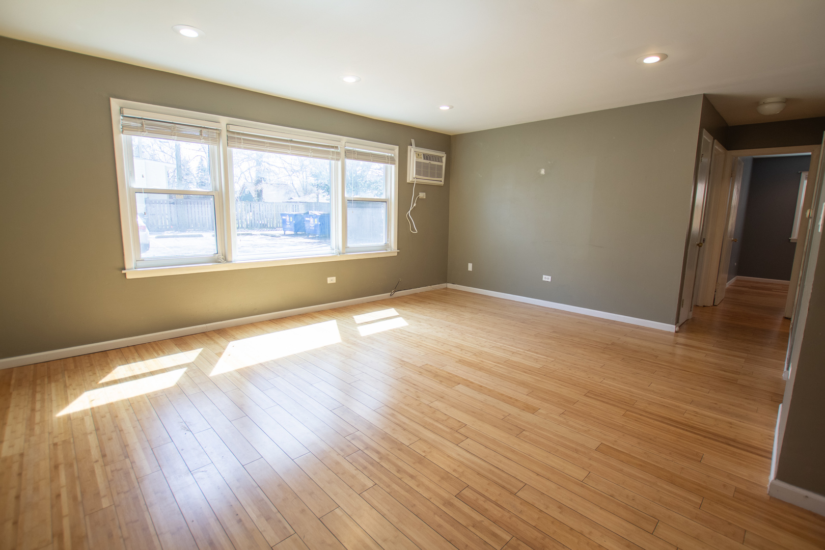 301 Chicago Avenue, Unit 1SW Oak Park, IL 60302 - Photo 3 of 12 an empty room with wooden floor and windows