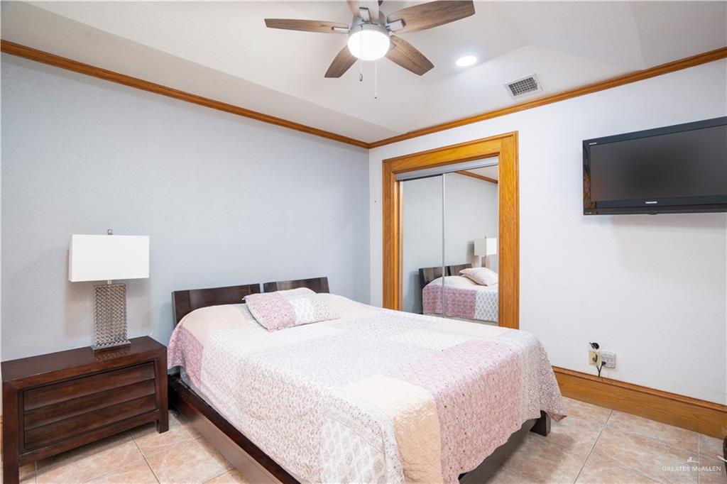 1701 Raul Aguilar Drive Mission, TX 78572 - Photo 16 of 43 a bedroom with a large bed and a flat screen tv