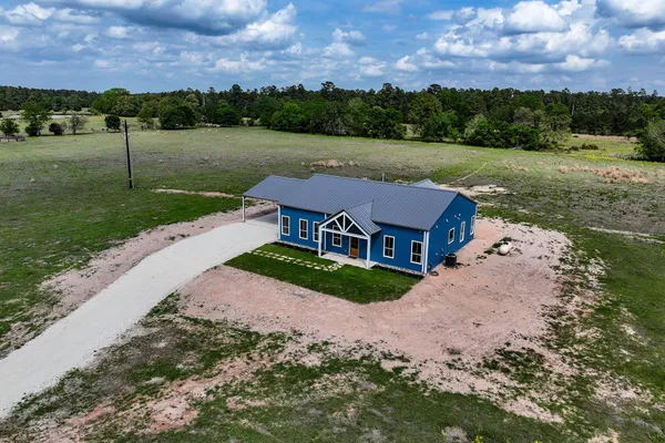 an aerial view of a house with big yard