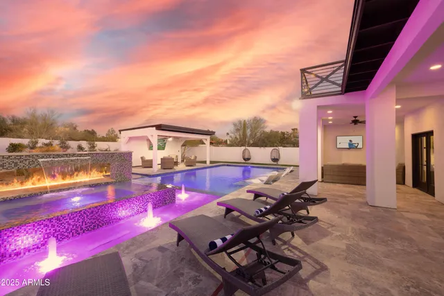 a view of a house with backyard patio and swimming pool