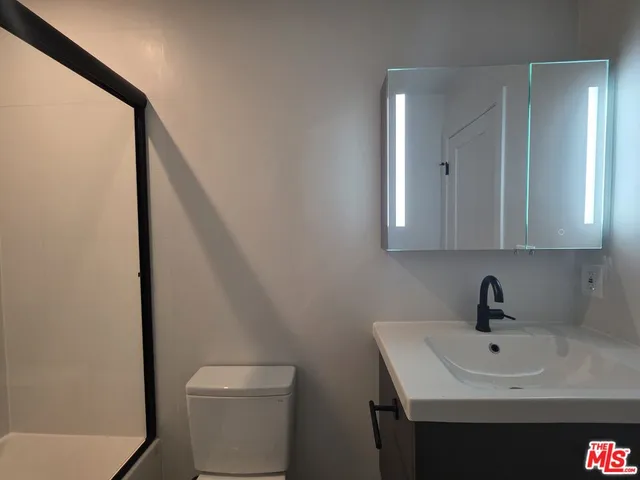a bathroom with a sink a toilet and mirror
