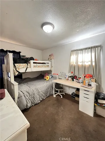 a view of a bedroom with furniture and window