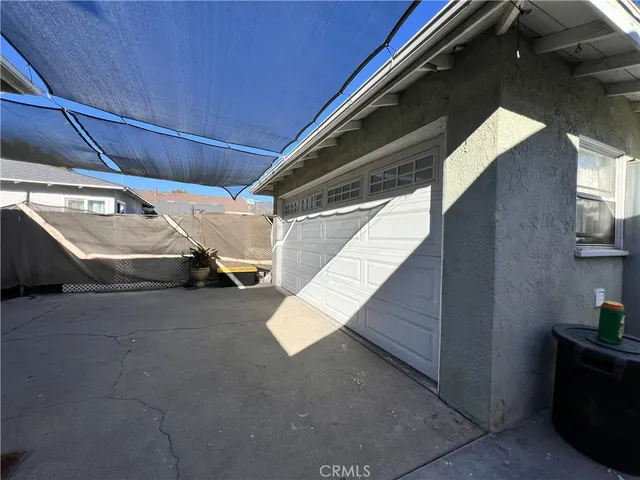 a patio with a table and chairs and a barbeque