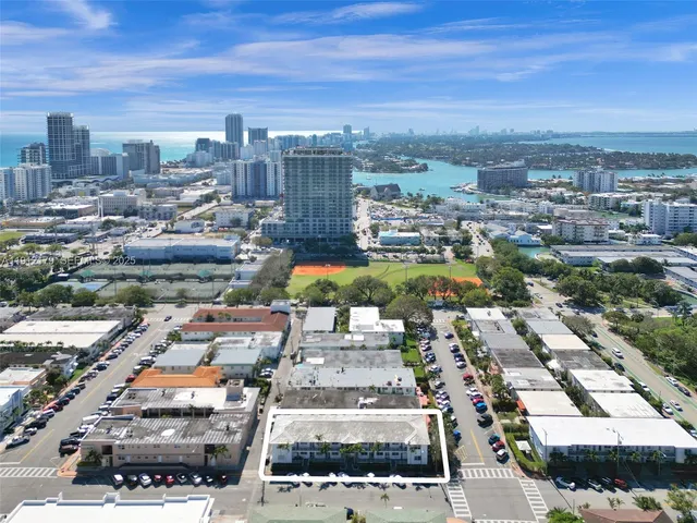 an aerial view of a city with ocean view in back