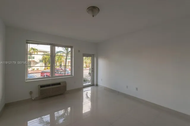 an empty room with windows and ceiling fan