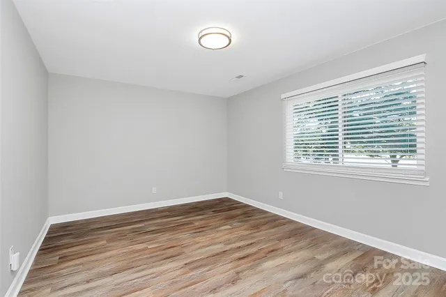 a view of a room with wooden floor and window