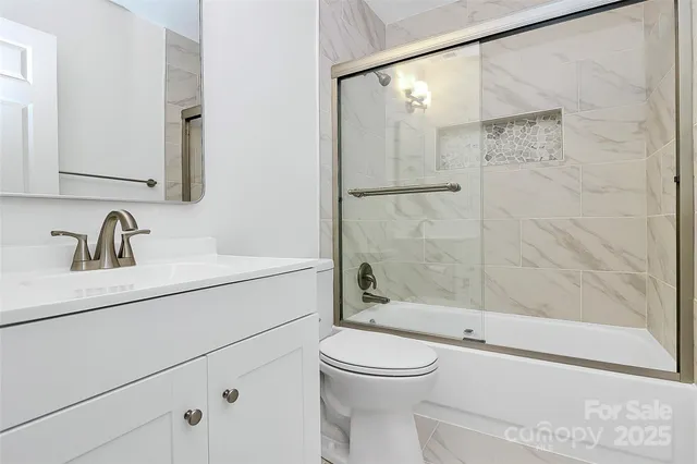 a bathroom with a sink a mirror a toilet and shower