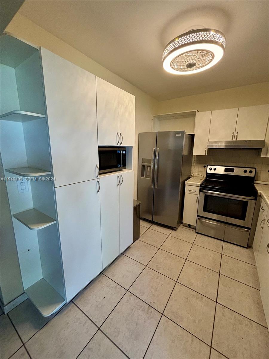 3521 Southwest 88th Court Miami, FL 33165 - Photo 4 of 12 a kitchen with a refrigerator a stove a microwave and a counter top space