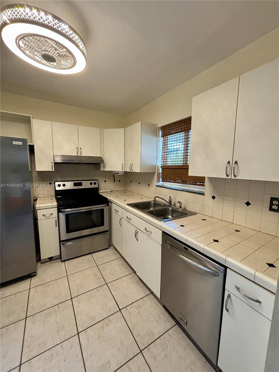 3521 Southwest 88th Court Miami, FL 33165 - Photo 5 of 12 a kitchen with a stove a sink and a refrigerator