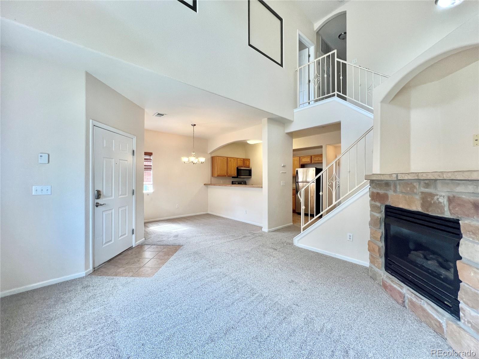 1385 South Chambers Road, Unit 102 Aurora, CO 80017 - Photo 6 of 20 a view of a livingroom with an empty space and a fireplace