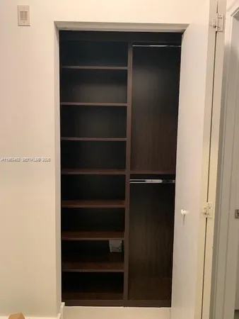 a view of walk in closet with empty racks