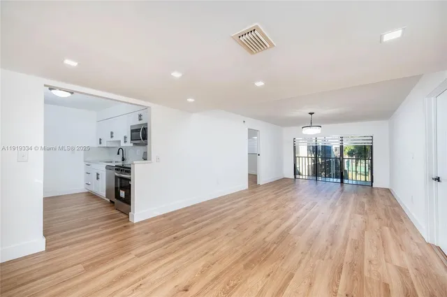 a view of a kitchen with wooden floor and a kitchen