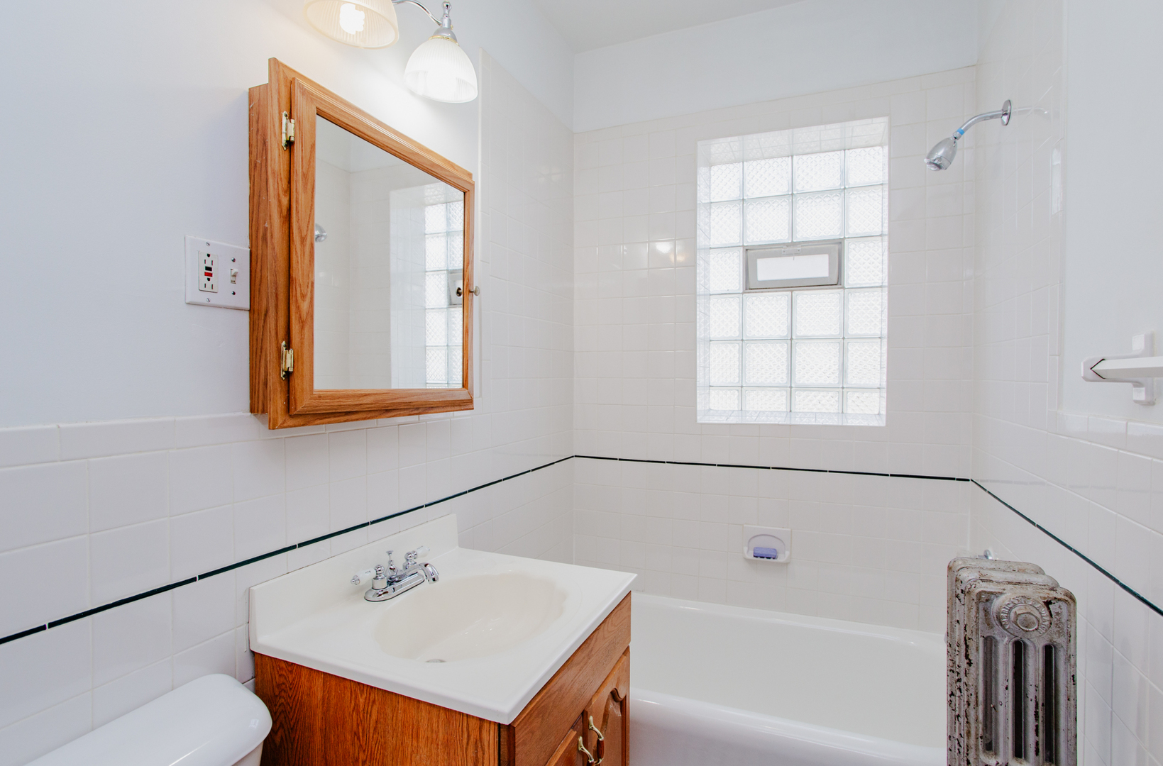 7639 Jackson Boulevard, Unit 1E Forest Park, IL 60130 - Photo 12 of 13 a bathroom with a bathtub a sink and a window