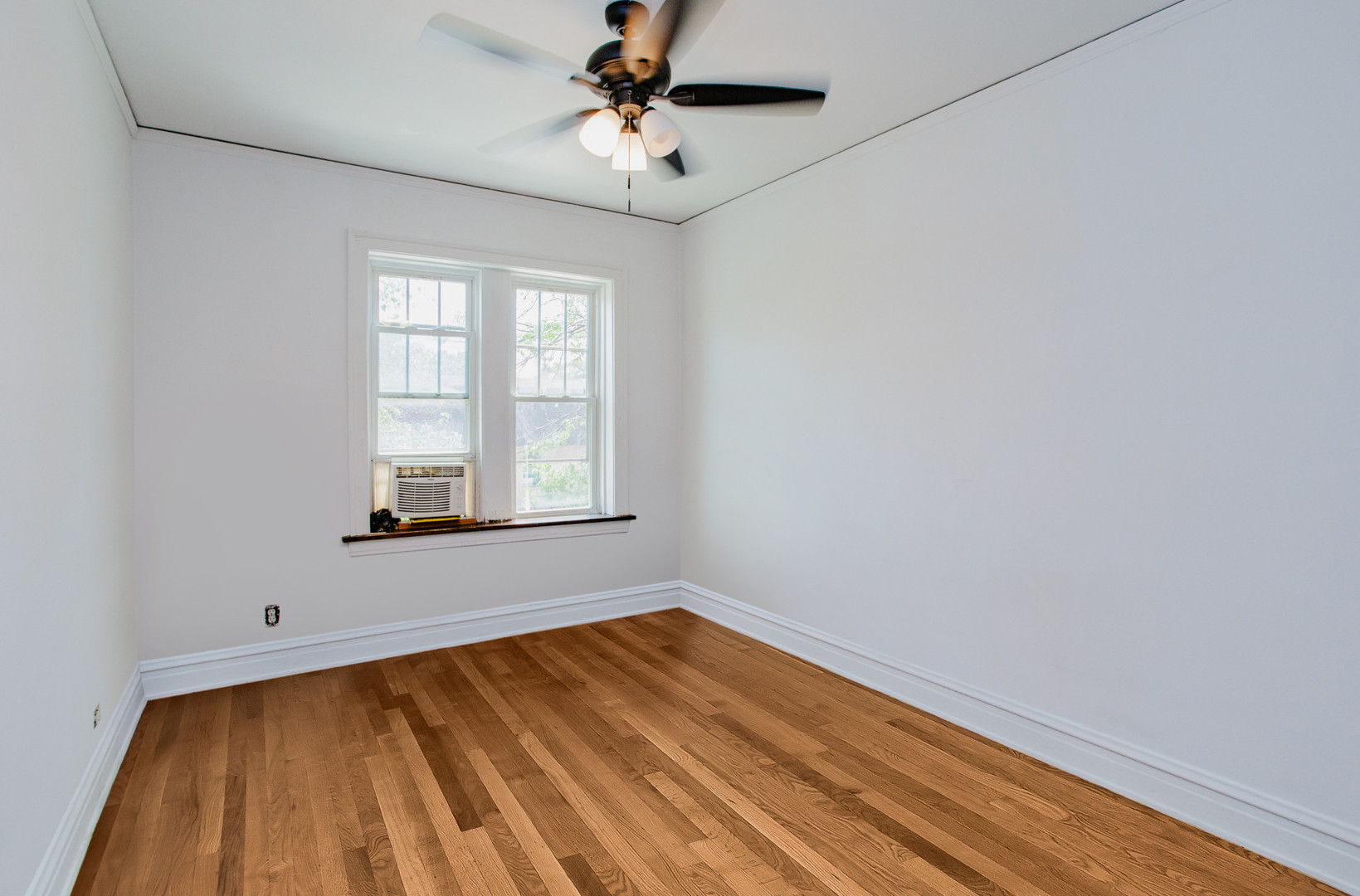 7639 Jackson Boulevard, Unit 1E Forest Park, IL 60130 - Photo 7 of 13 a view of empty room with wooden floor and fan
