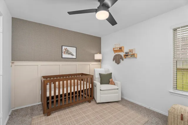 a room with a baby crib and dresser