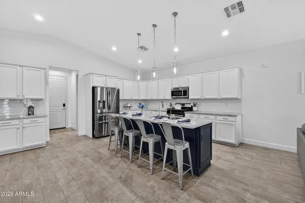 a large kitchen with kitchen island a sink a center island stainless steel appliances and a cabinets