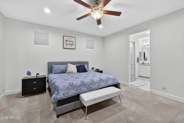 a spacious bedroom with a bed and a chandelier