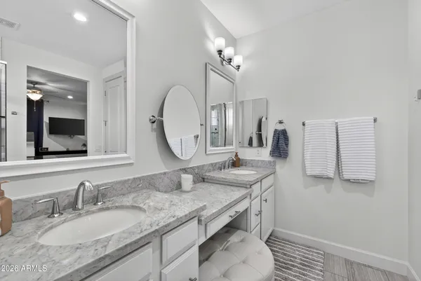 a bathroom with a granite countertop double vanity sink and a mirror