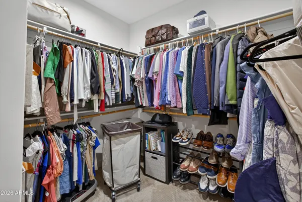 a view of walk in closet with clothes and shoes