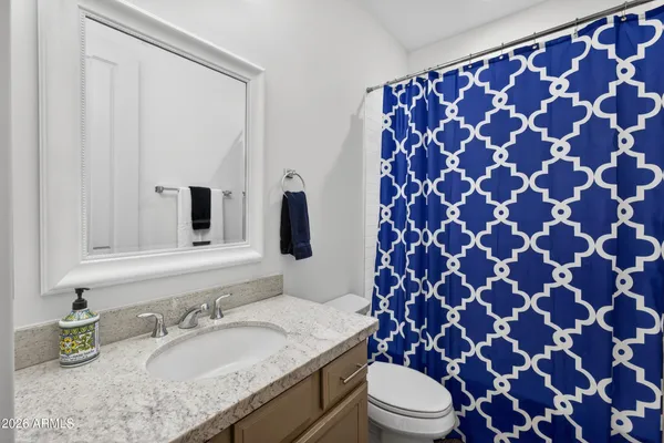 a bathroom with a granite countertop toilet sink and mirror