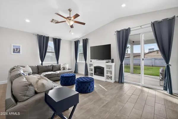 a living room with furniture a flat screen tv and a fireplace