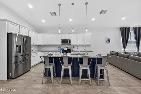 a kitchen with kitchen island a dining table and stainless steel appliances